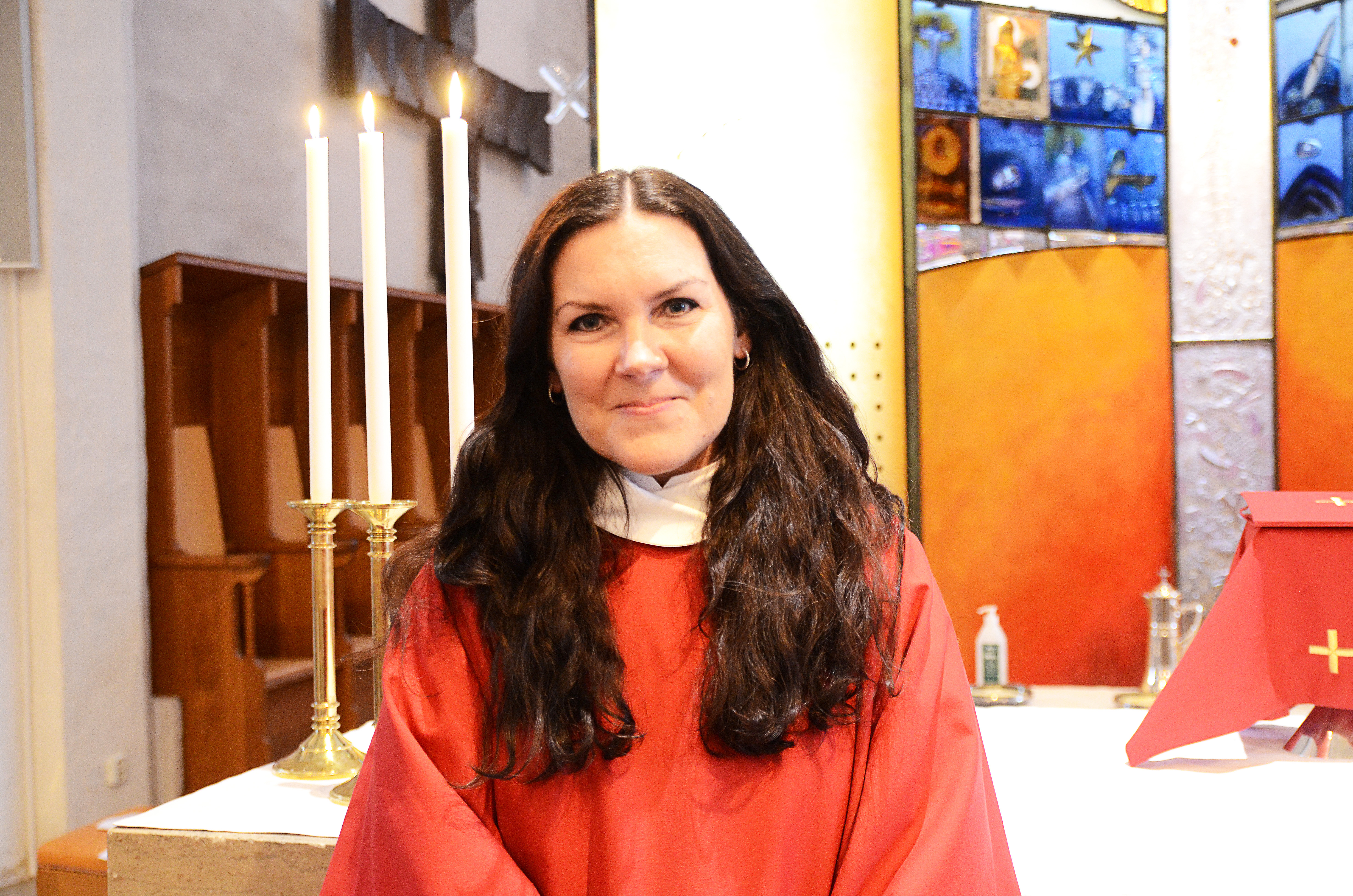 Porträttbild på Erika Zander Lutgård, som bär liturgiska kläder i rött.