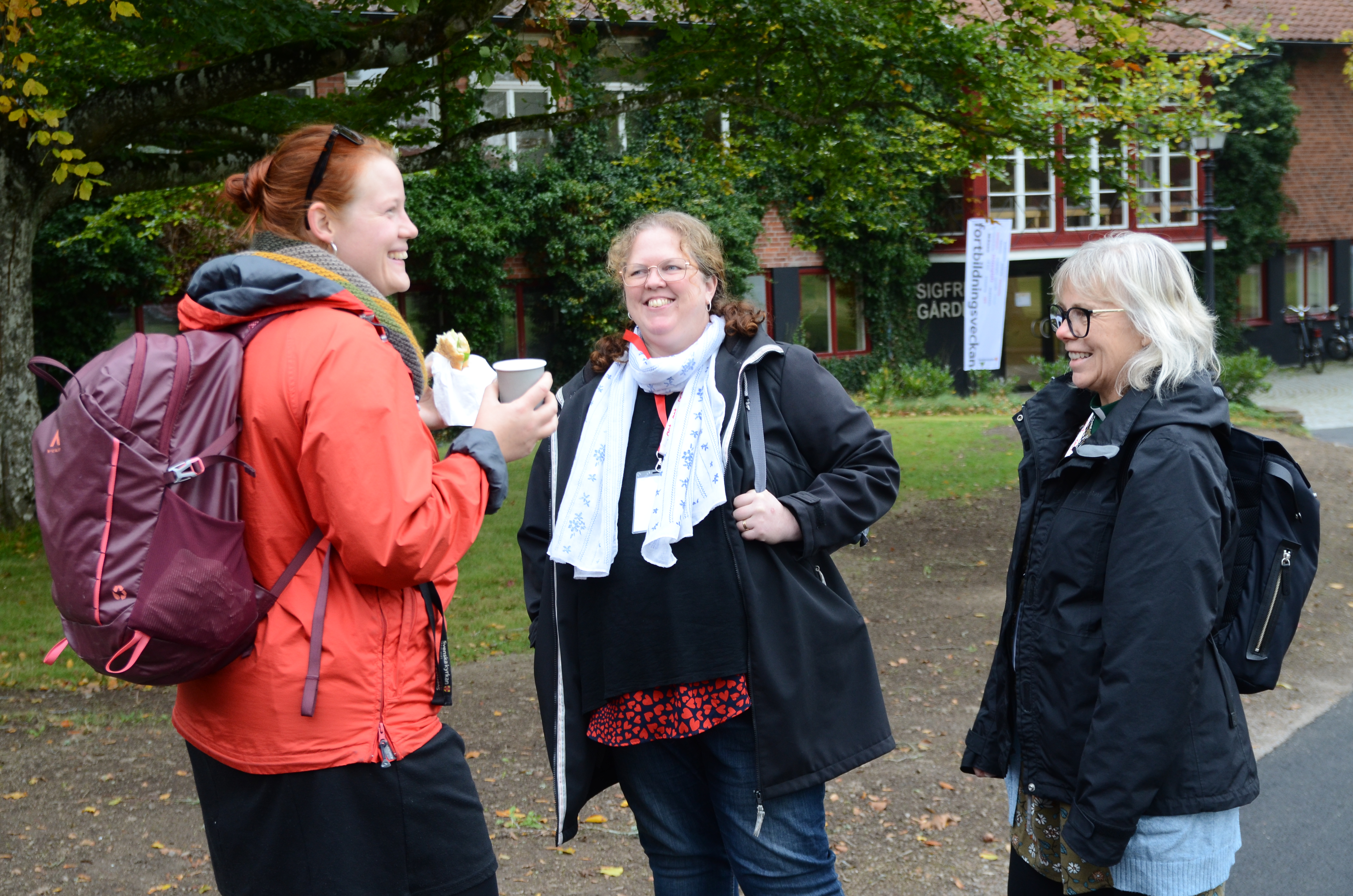 Tre diakoner som deltog under Fortbildningsveckan samtalar utomhus under en paus.
