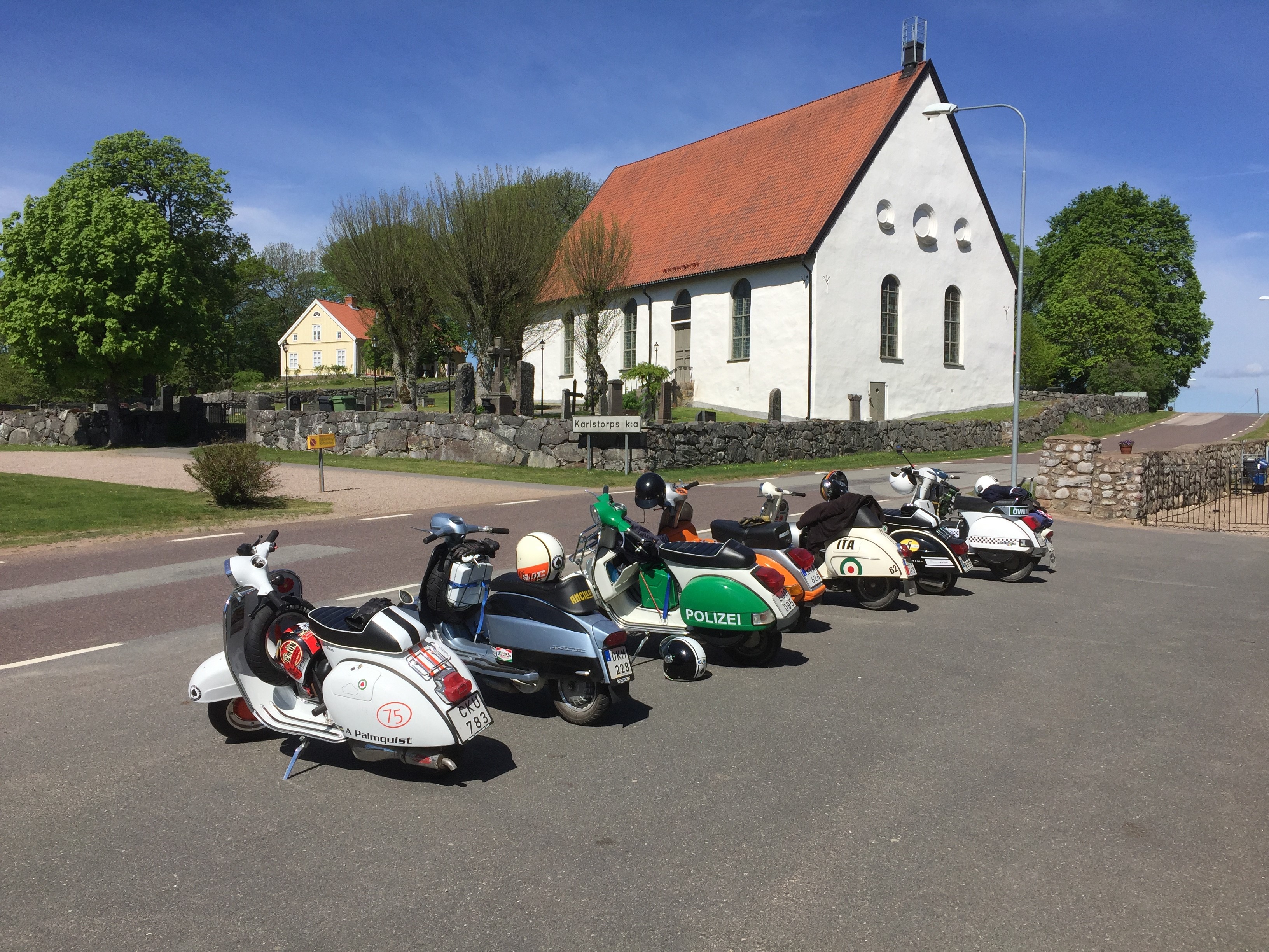 Vespor parkerade framför Karlstorps kyrka, en av pastoratets 24 kyrkor.