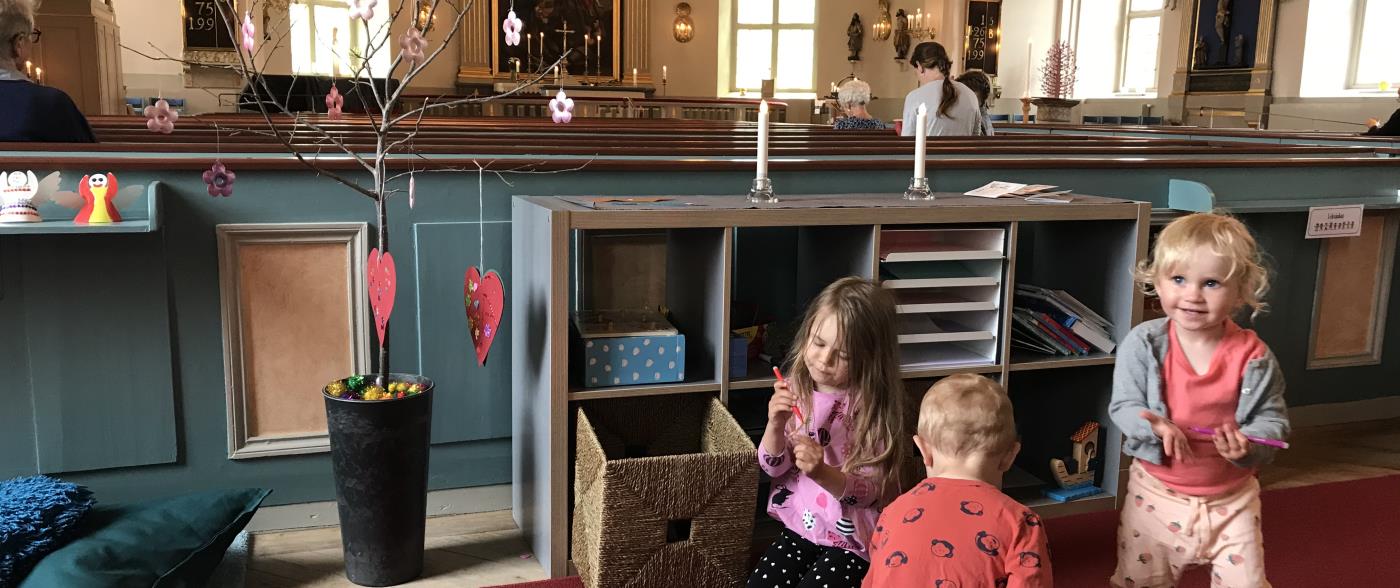 Ellen, Lilly och Sakarias leker i barnhörnan i Mönsterås kyrka. Barnhörnan är placerad i mitten av kyrkan. Placeringen möjliggör för barn och föräldrar att aktivt delta i gudstjänsten och samtidigt hålla fingrarna sysselsatta.