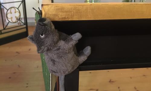 En grå tygmus som klättrar på altaret