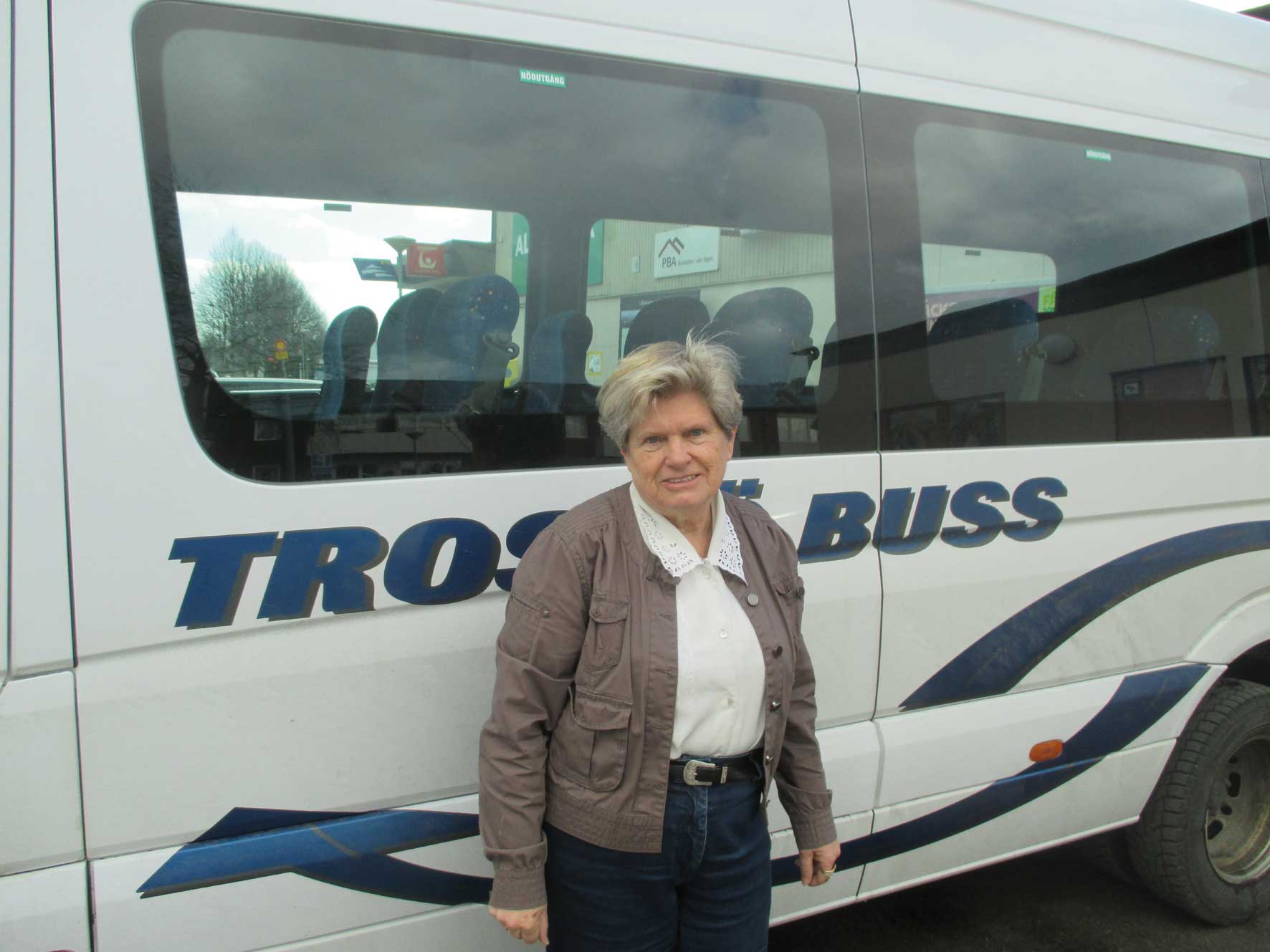 En kvinna stående vid sidan av en buss.