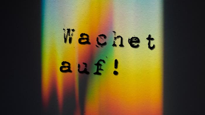 Texten Wachet auf på färgglad bakgrund