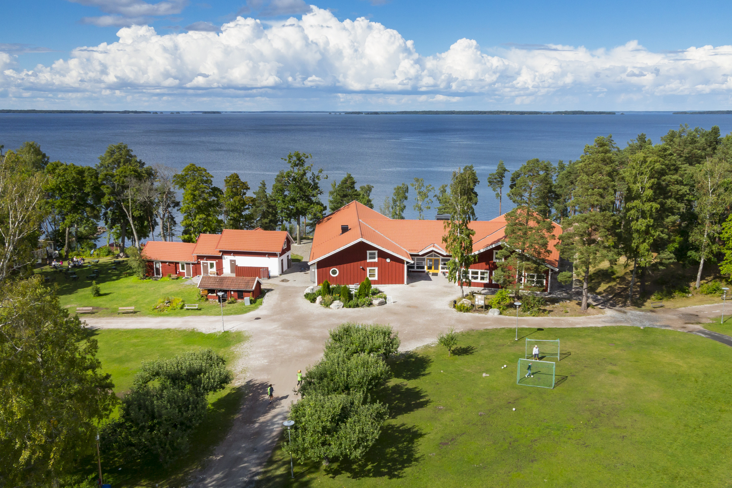 Röda byggnader i förgrunden, ett stort vatten