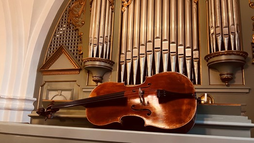 Fiol framför en kyrkorgel.