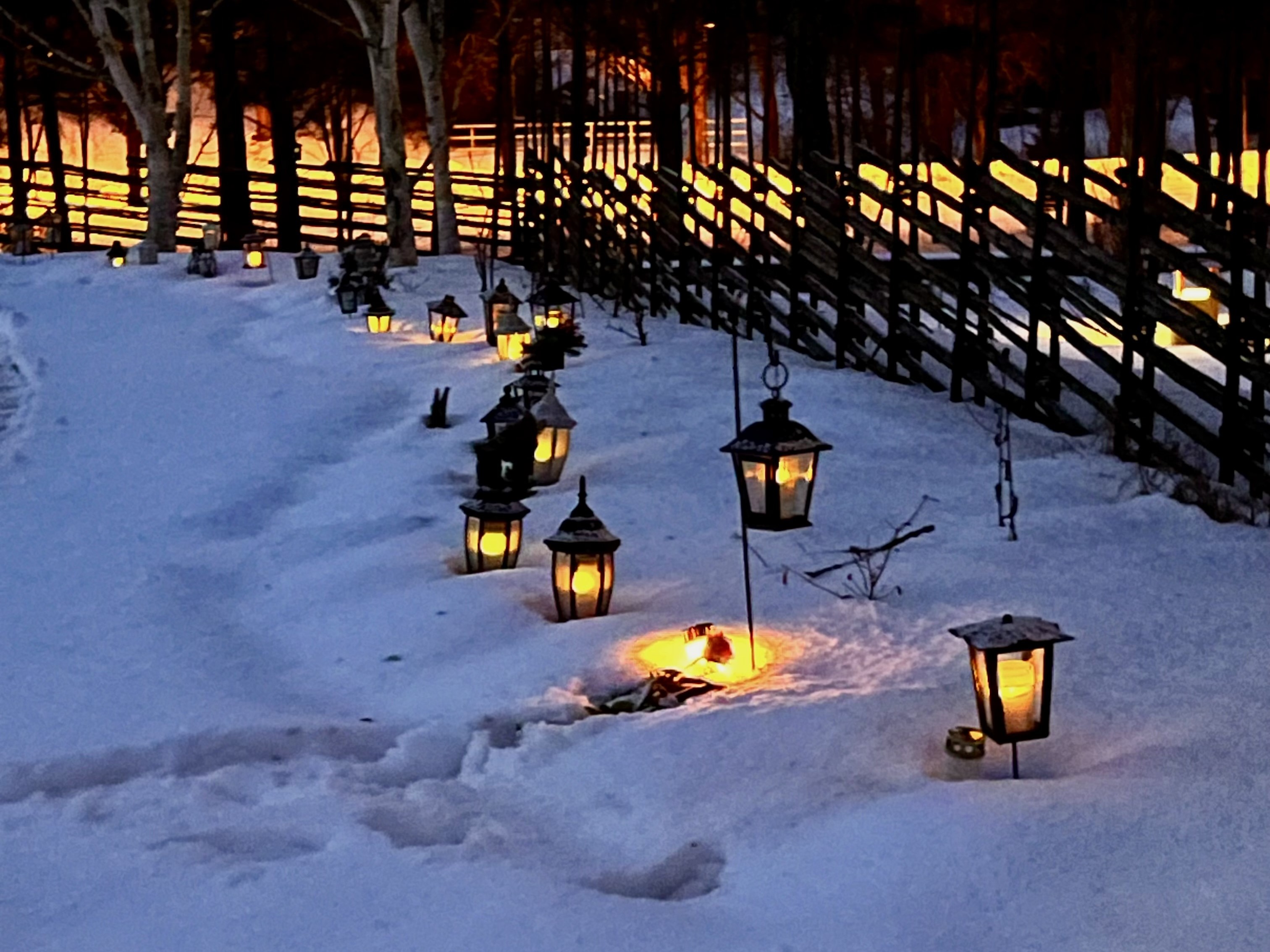 Gravar med lyktor på griftegård. Snö på marken.