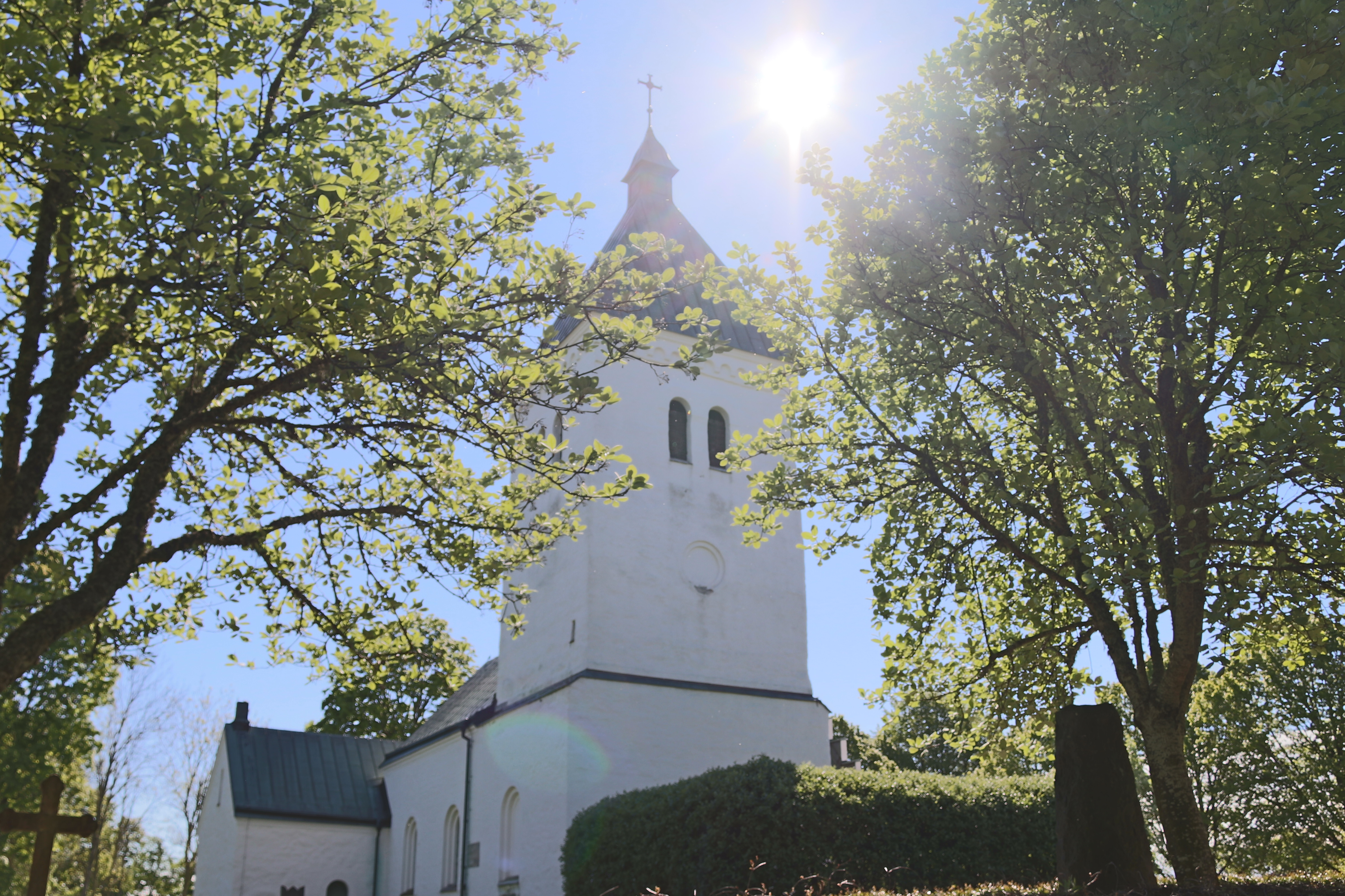 Vit kyrka i solsken.