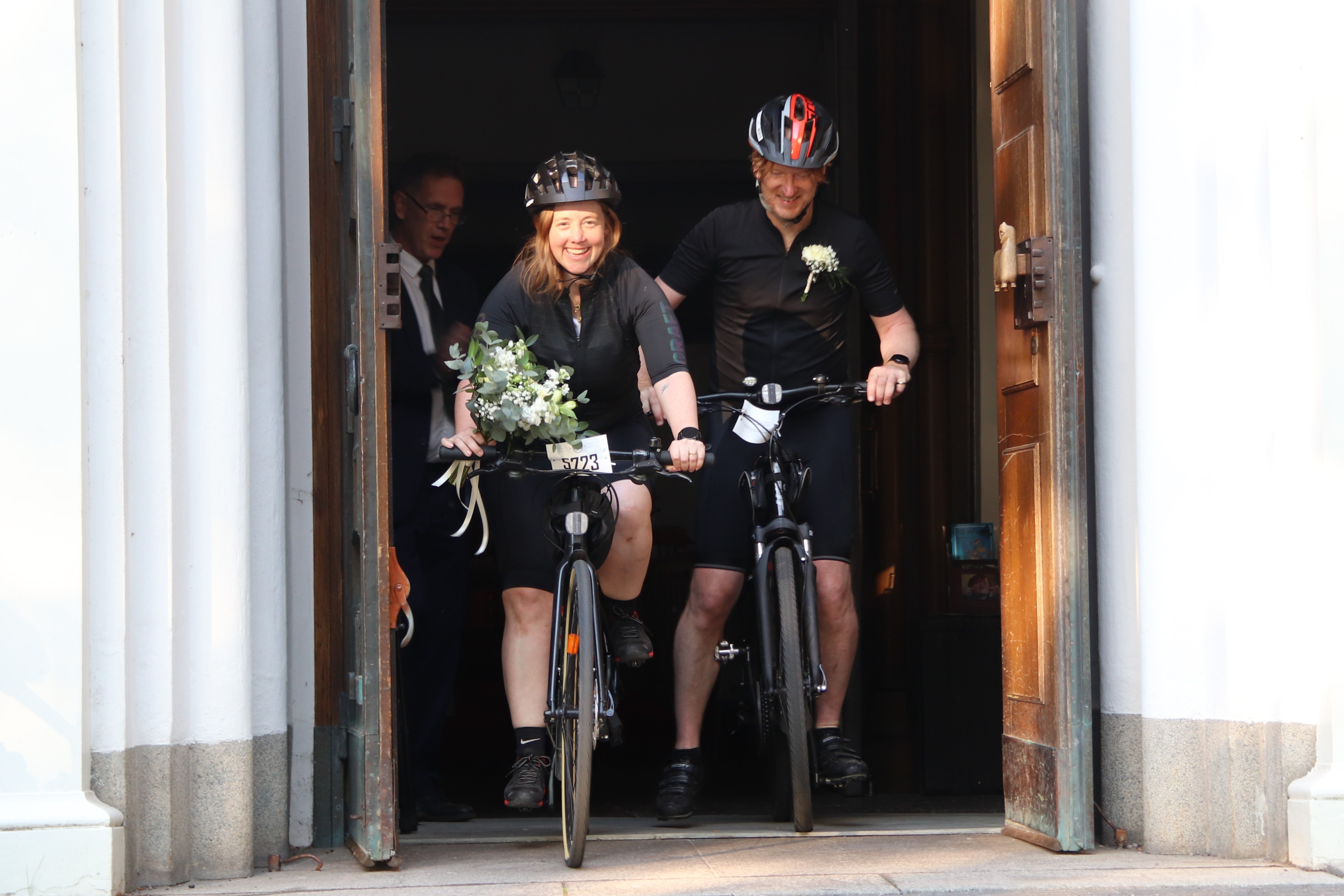 Vigselpar cyklar genom kyrkporten
