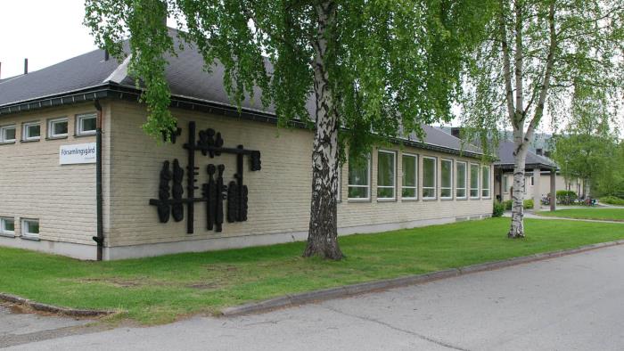 Framsidan av Sollefteå församlingsgård. Byggnaden omgiven av försommargröna björkar.