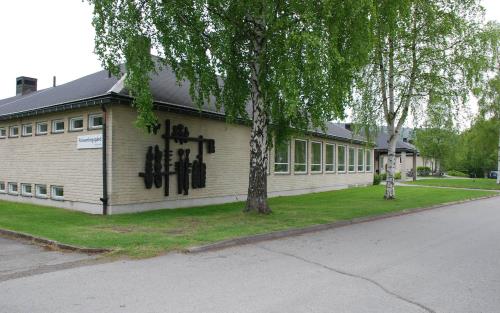 Framsidan av Sollefteå församlingsgård. Byggnaden omgiven av försommargröna björkar.