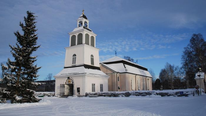 Sollefteå kyrka. En vinterbild. Till vänster står en stor gran.