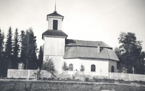 Ett äldre svartvitt fotografi av Gålsjö kapell. Framför kapellet står en man med cykel