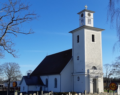 Ryssby kyrkas torn mot en blå himmel.
