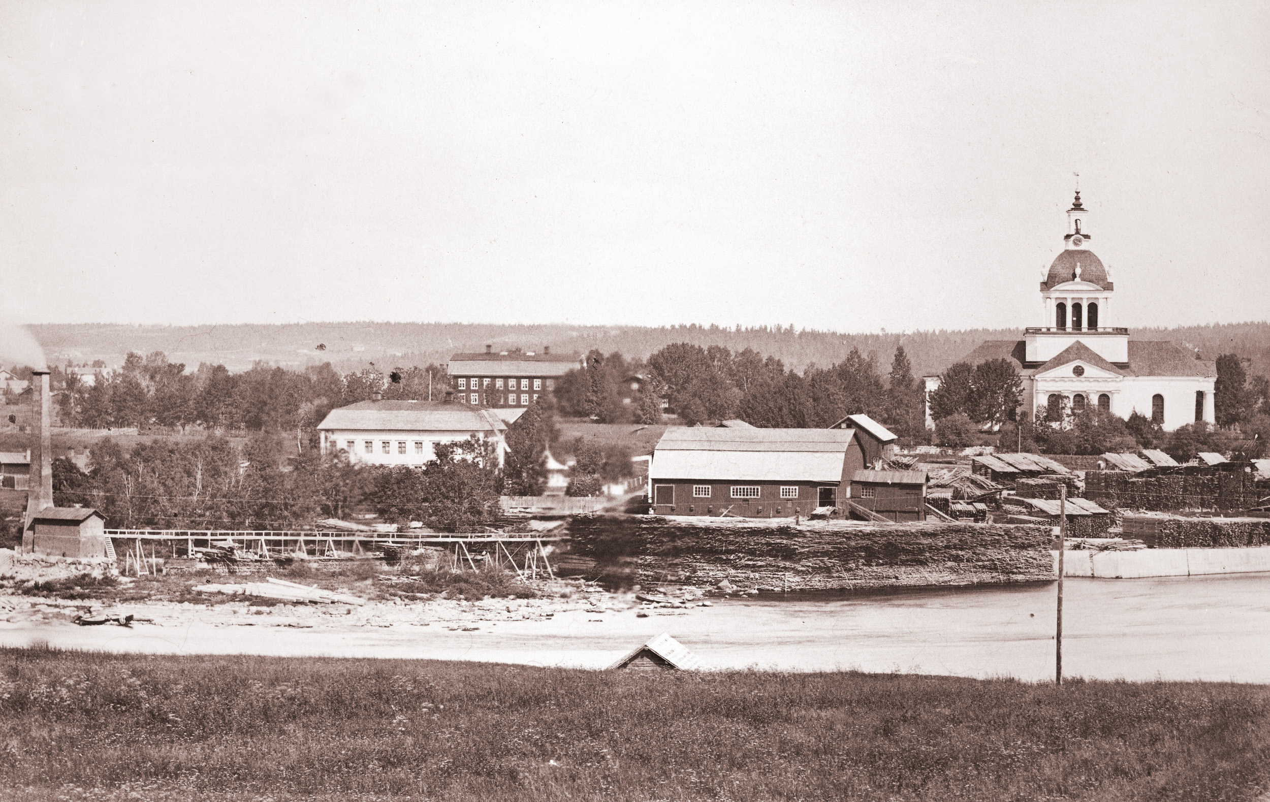 I förgrunden Lejonströms herrgård och sågverk. Bakom ligger Stiftsgården som här är rödmålad och landskyrkan längst till höger. Troligen på 1860-talet.