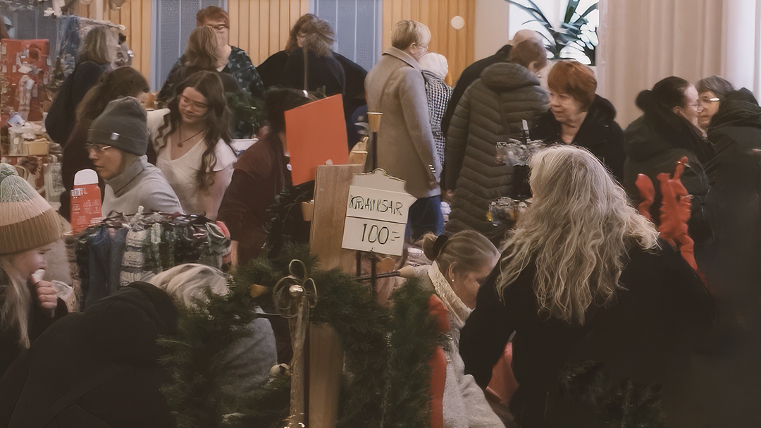 Bilden föreställer människor i en lokal där en marknad pågår