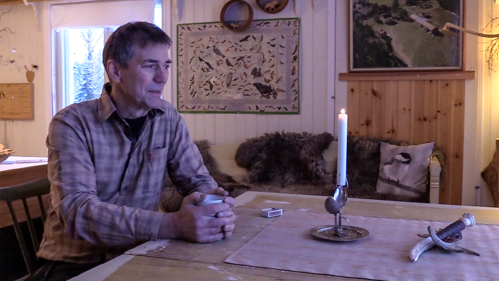 Per-Anton Hedenström sitter vid ett bord och dricker kaffe. Han har tänt ett ljus.