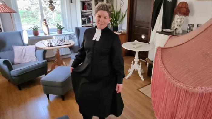 Sara Pettersson, kyrkoherde i Burträsk-Lövångers pastorat, iklädd en svart kaftan, fångad mitt i en rörelse. 