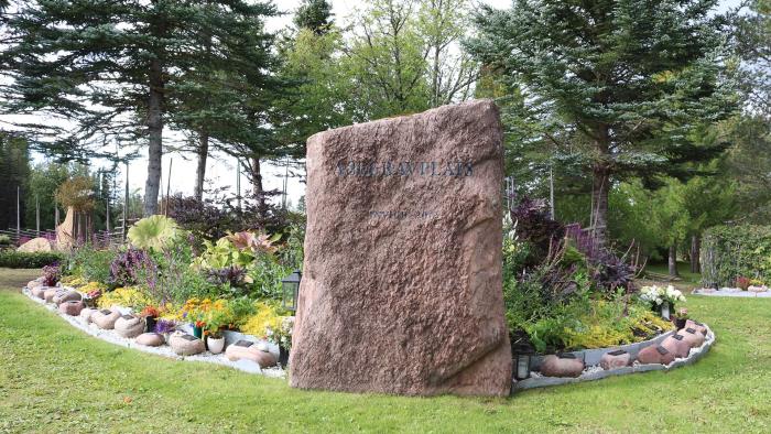 Gravområde på kyrkogård med stor sten märkt ASKGRAVPLATS