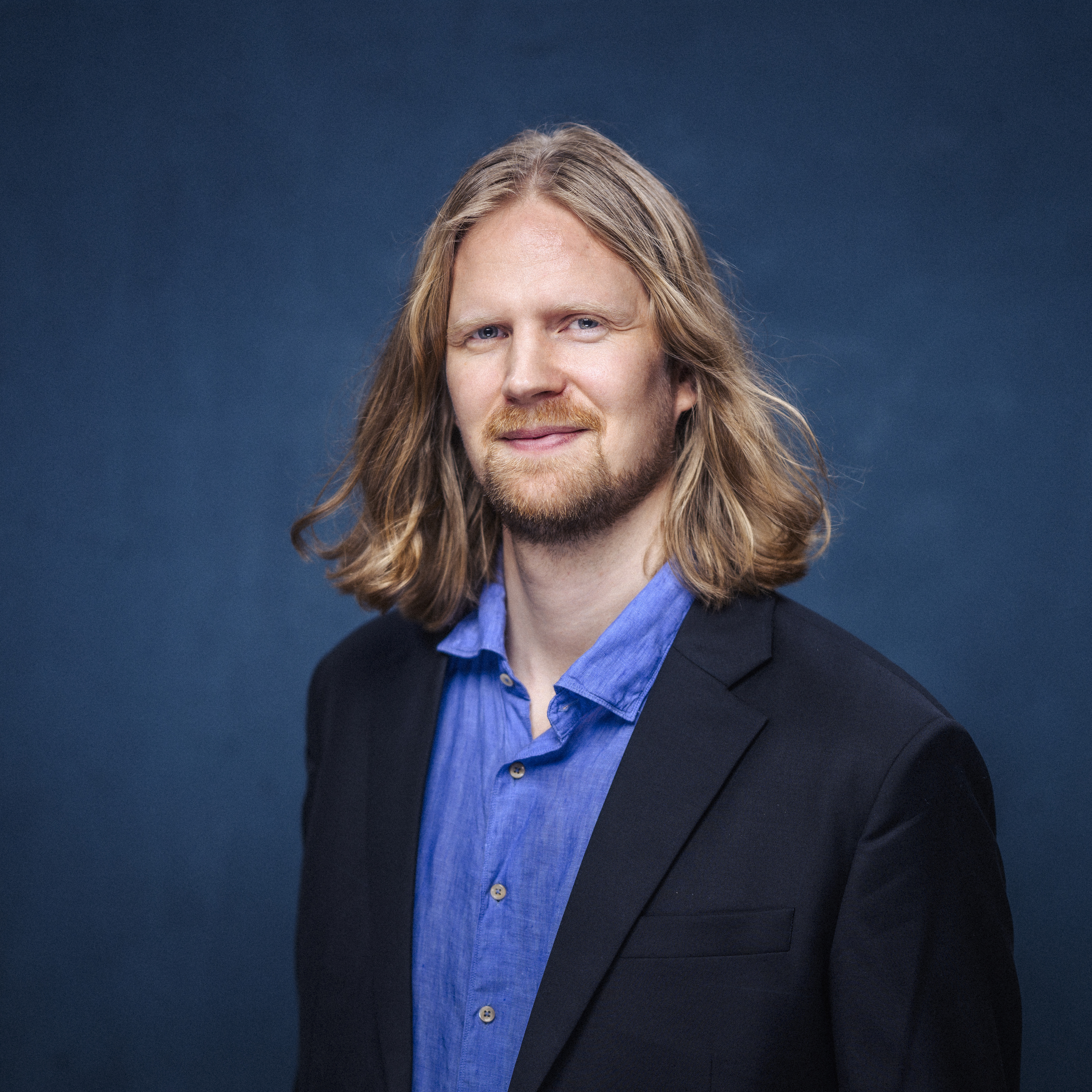 Porträttbild av Kalle i blå skjorta och kavaj