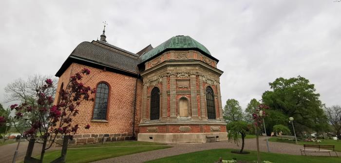 Askersunds landskyrka omgiven av gröna gräsmattor och blommande rabatter