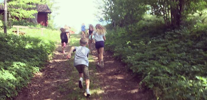 Barn som springer längs en väg i skogen