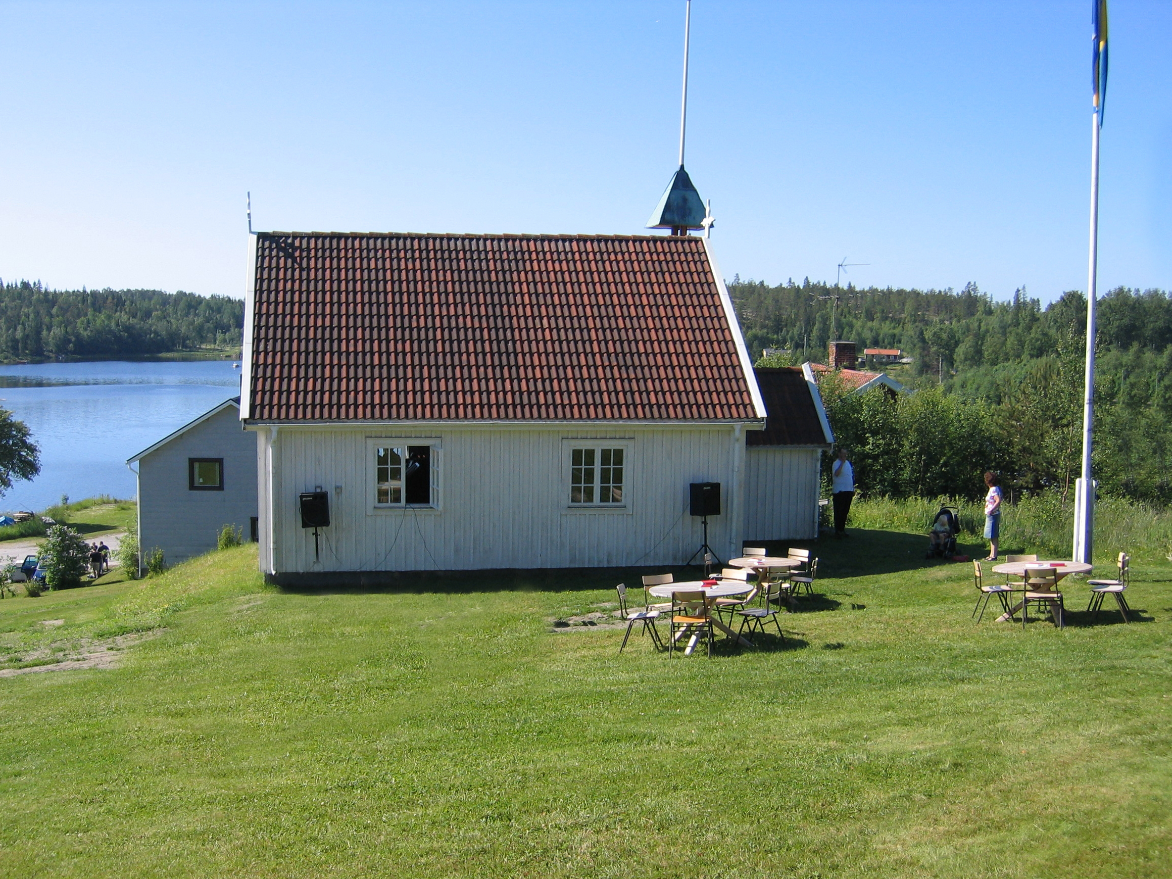 Kapell, gräsmatta,flaggstång. Havet i bakgrund.