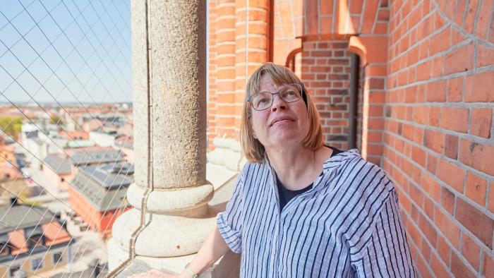 Annika Franzon står på domkyrkobalkongen och blickar uppåt.