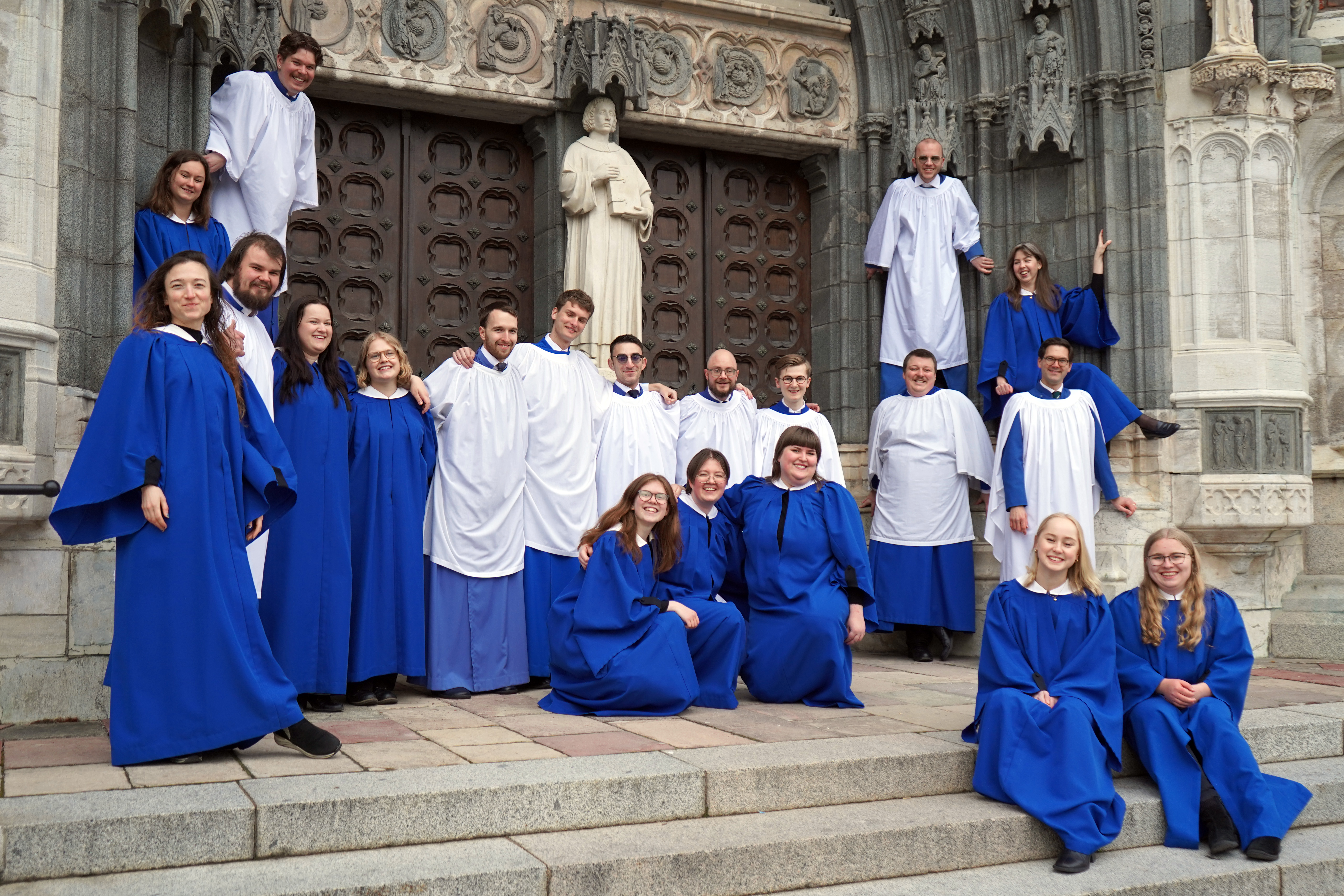 Schola Cantorum grupperade framför Uppsala domkyrkas södra port iförda sina klart blå och vita kåpor.