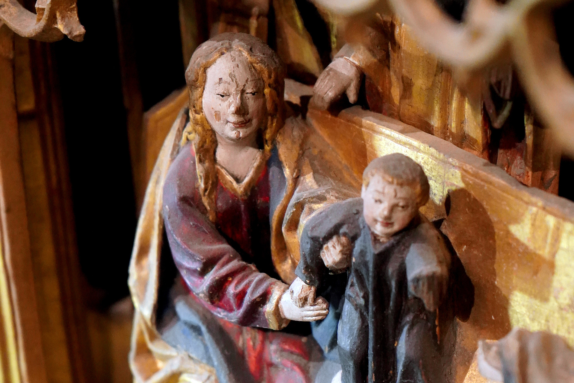 Fint snidade träfuigurer föreställande Maria och Jesusbarnet, färgglatt målade i en förgylld omgivning. Detalj från Sturekorets altarskåp från Skånela.