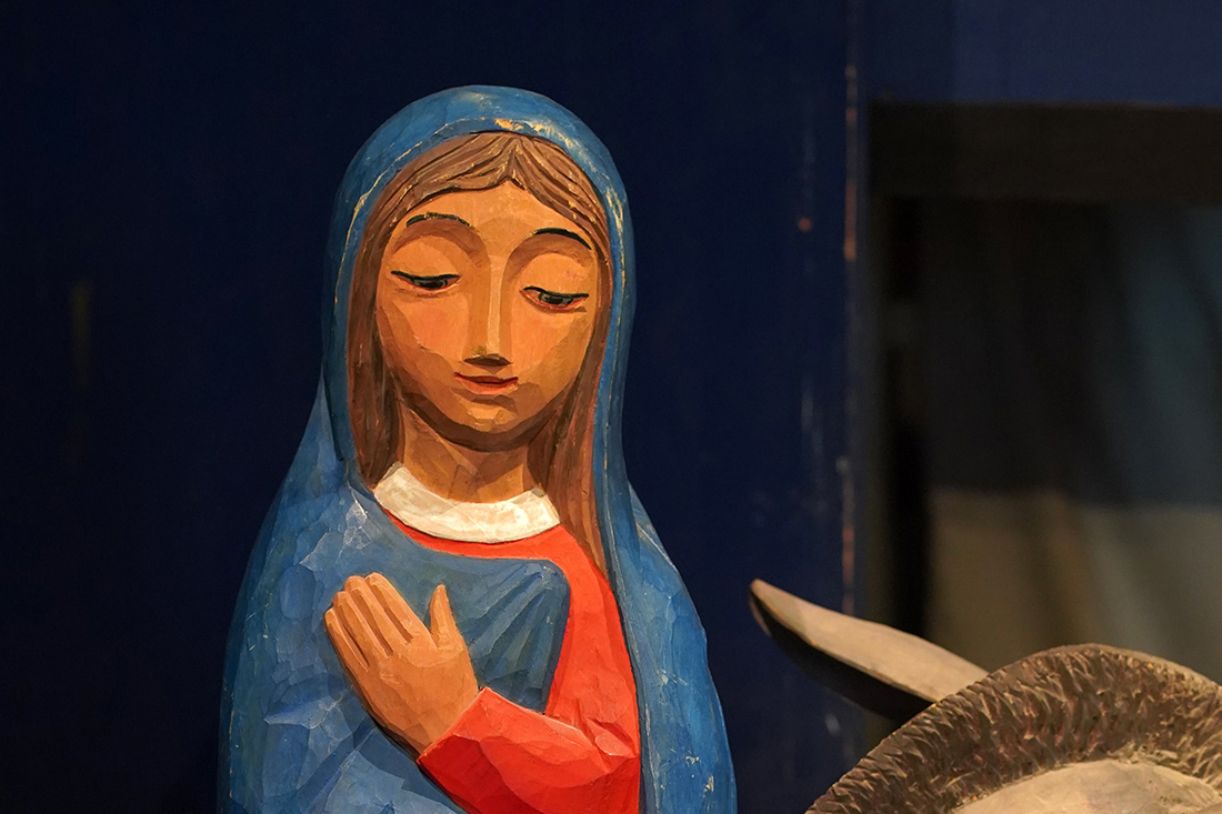 Jungfru Maria i blått och rött, gestalötad som träskulptur av Eva Spångberg i Uppsala domkyrka.