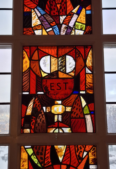 Kyrkfönster med en bild av kalken. 