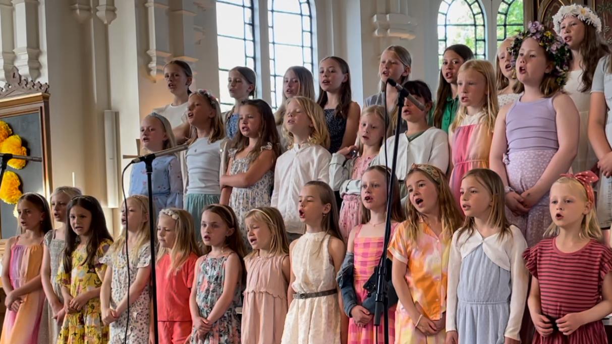 Glada barn i barnkör sjunger vid en konsert i Håslövs kyrka i Höllvikens församling 