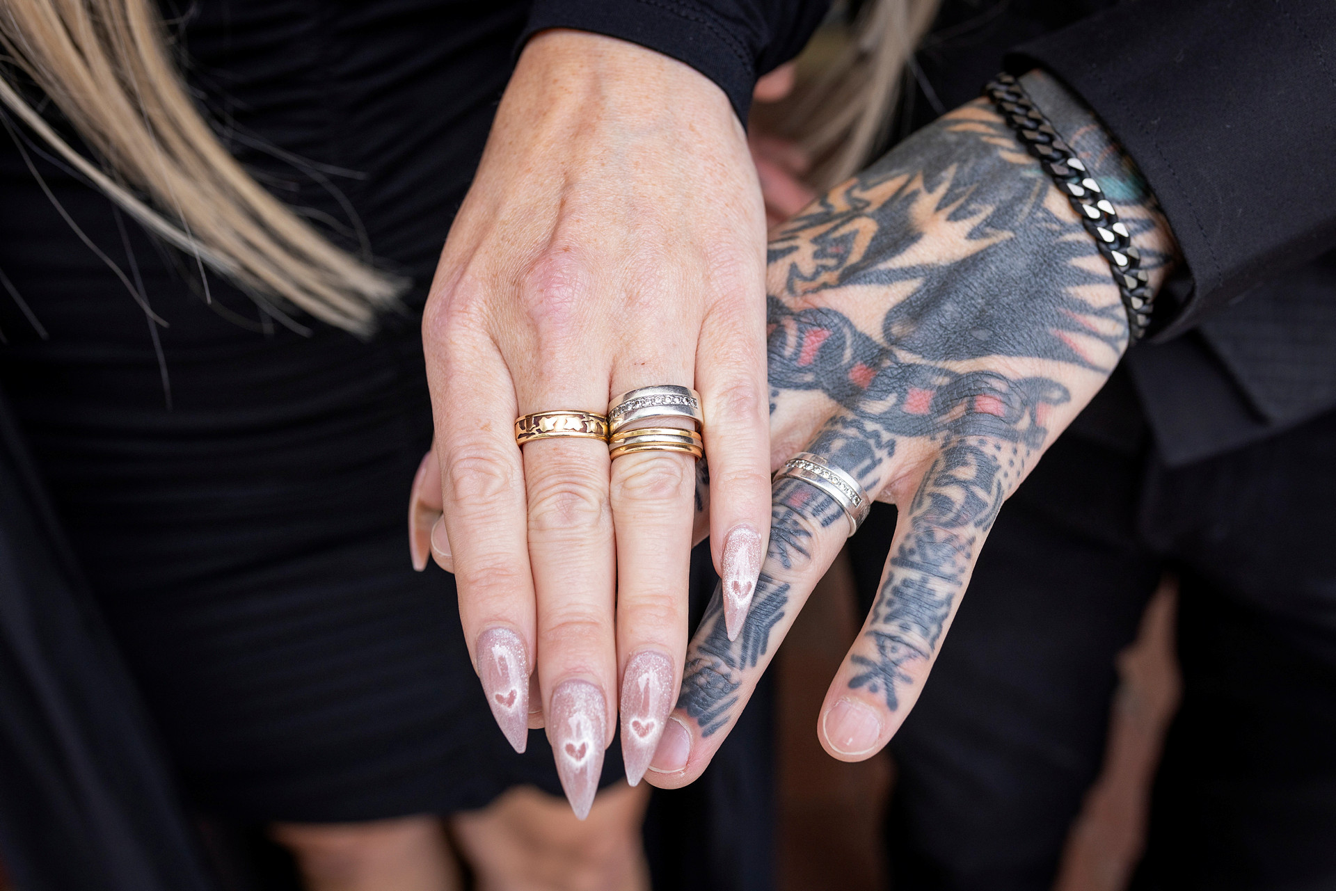 En man och en kvinna visar upp sina vigselringar. 