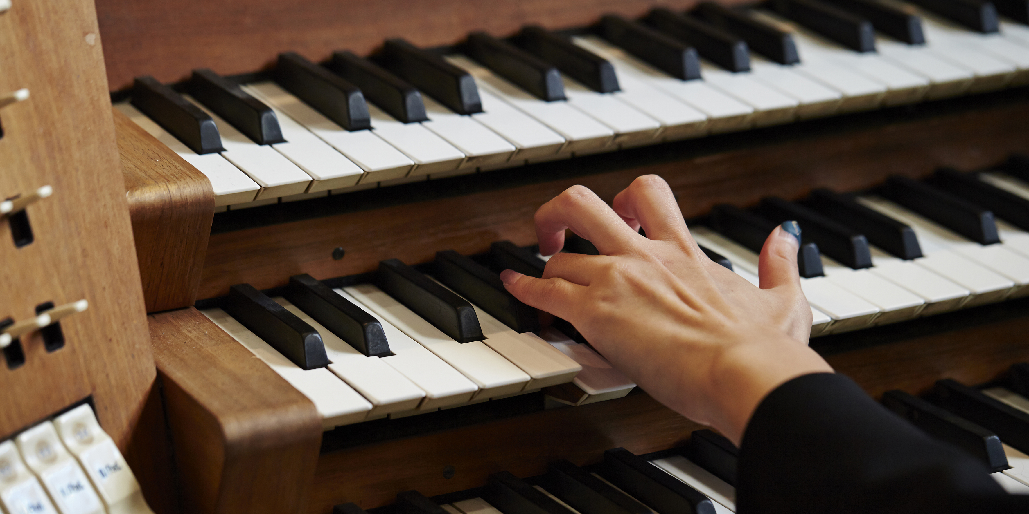 Anonym hand spelar orgel i kyrkomiljö. 