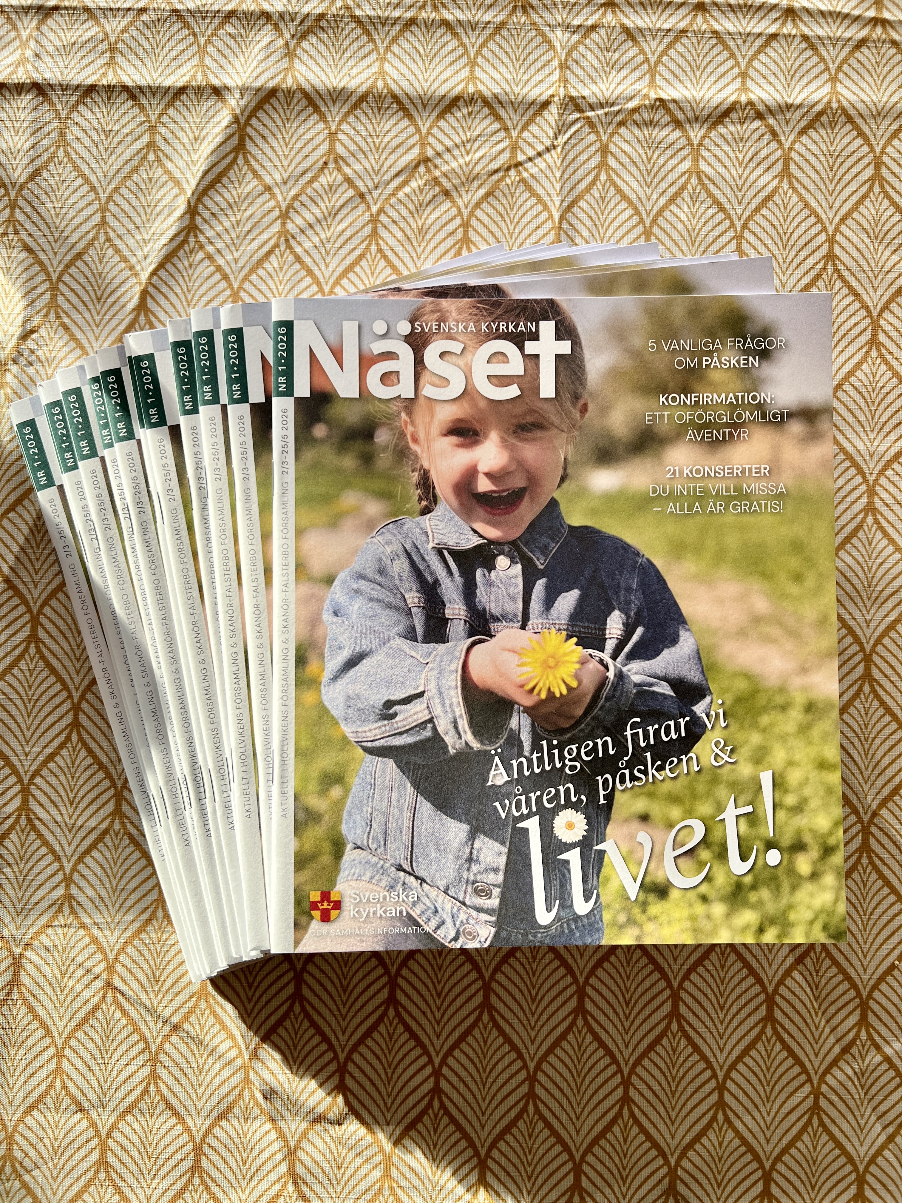 Flera nummer av tidningen Näset ligger på ett bord med en gul duk.