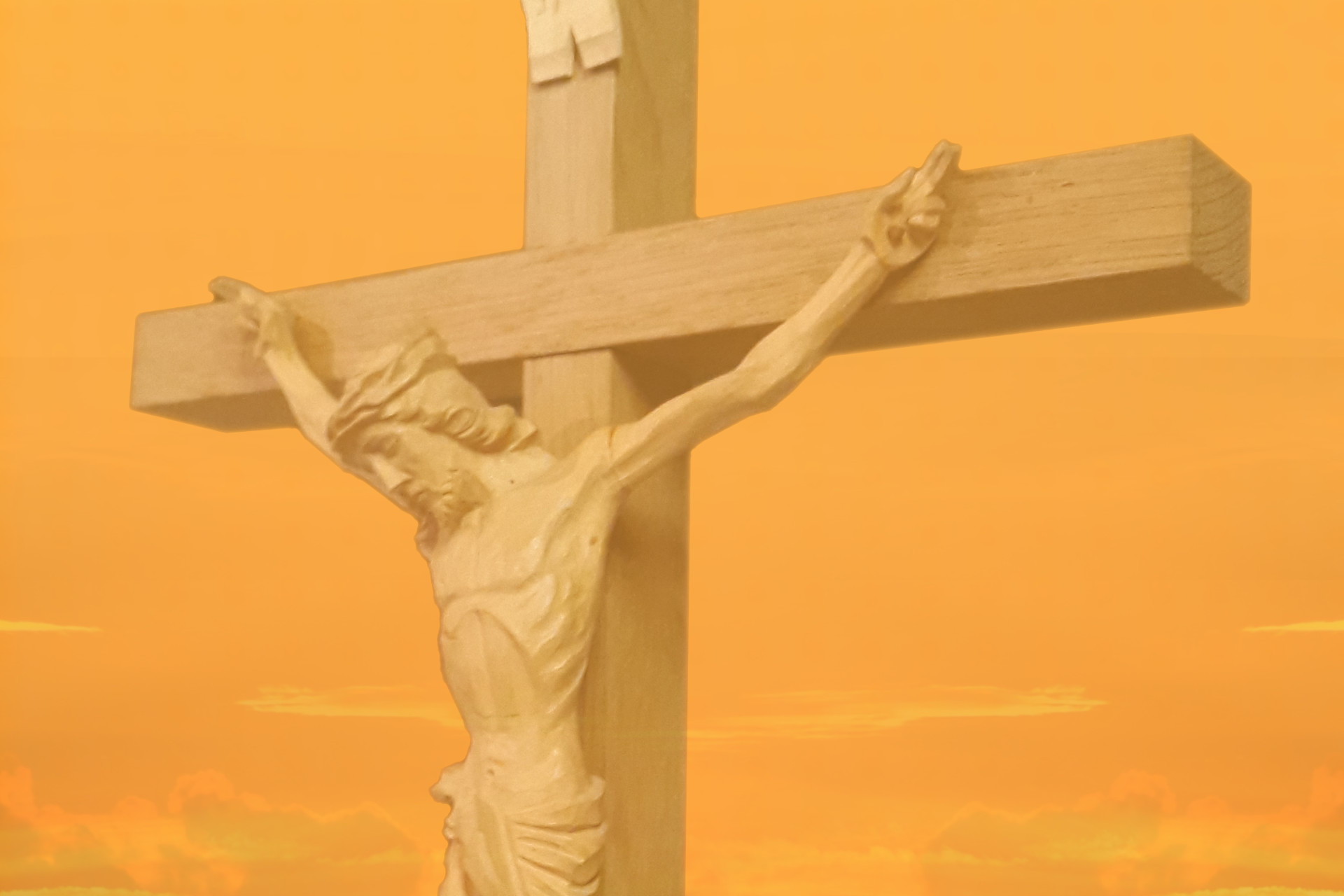 Bureå kyrkas altarcrucifix mot en gulaktig himmelsbakgrund