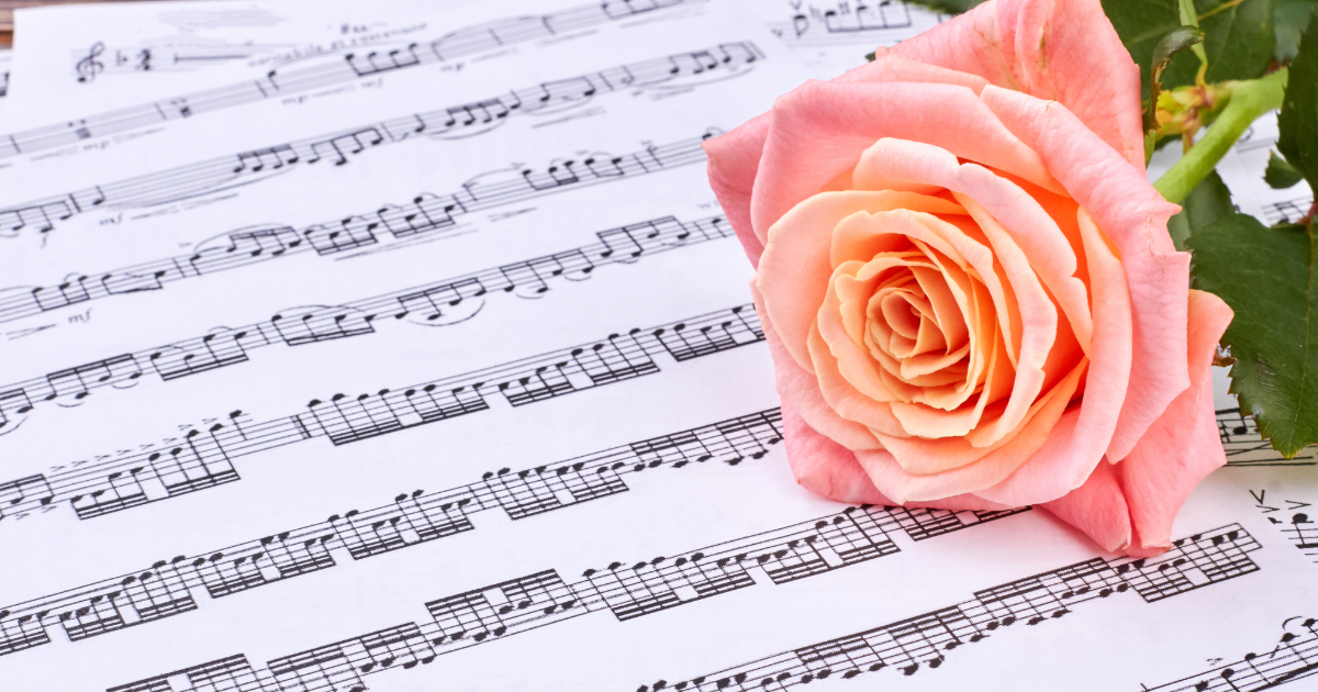 Musiknoter och en rosa ros.