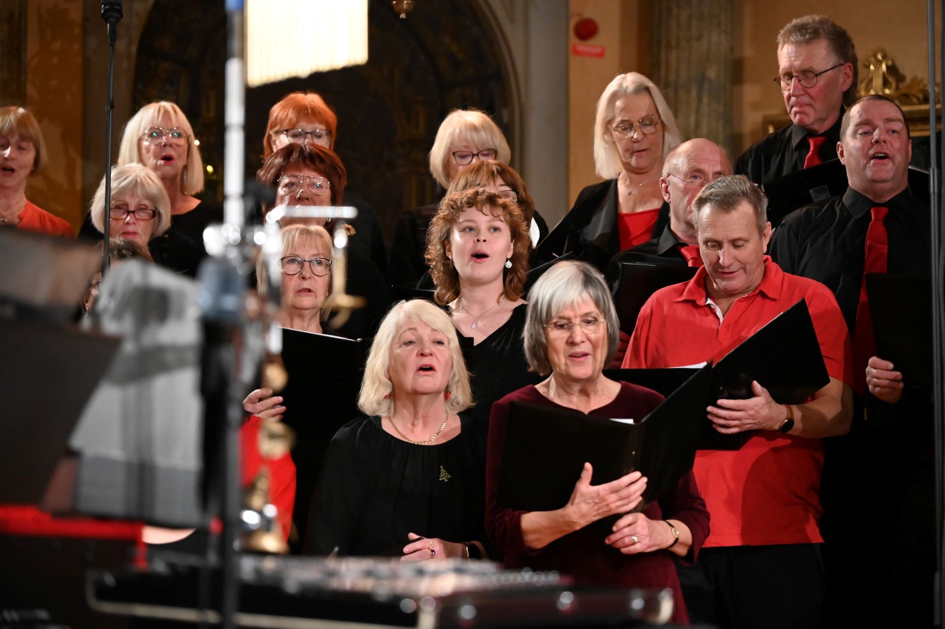 Körsångare står tätt intill varandra och sjunger