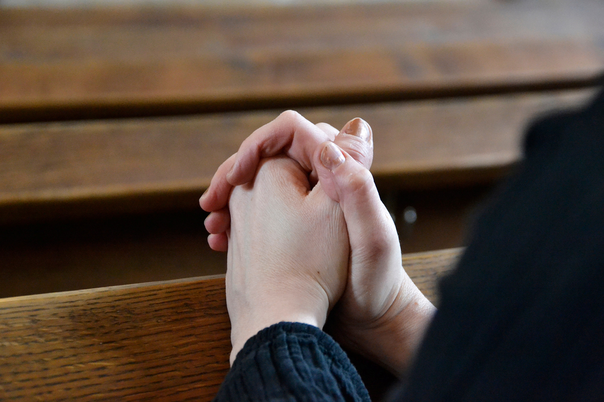 knäppta händer i kyrkbänk
