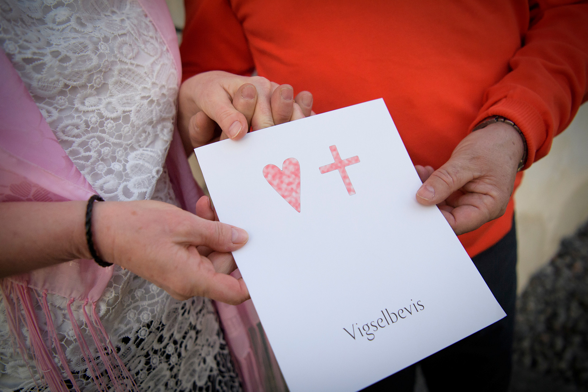 vigselpar håller i ett vigselbevis