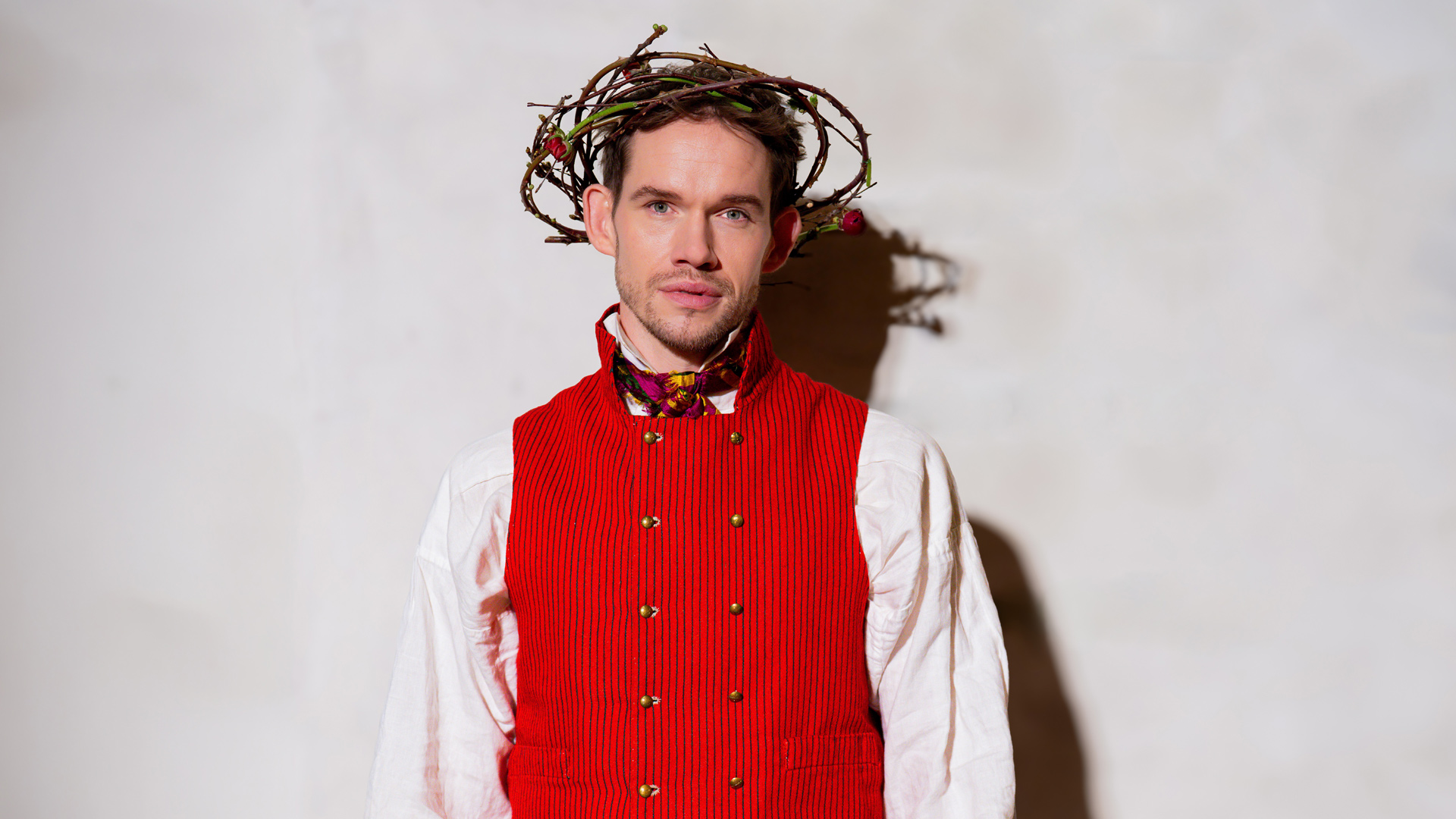 Musikalens huvudrollsinnehavare David Alvefjord klädd i svensk folkdräkt och med en törnekrona på huvudet.