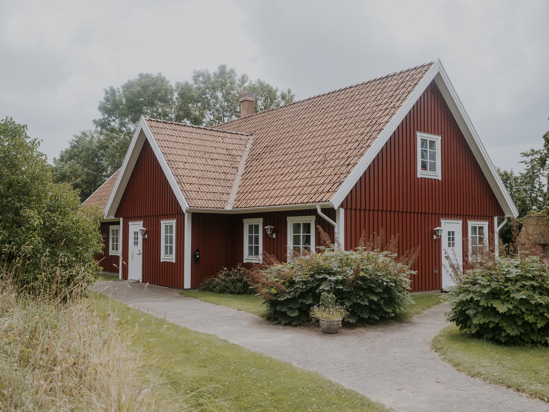 Bild på utsidan av Hallaröds församlingshem. Rött trähus med vita knutar.
