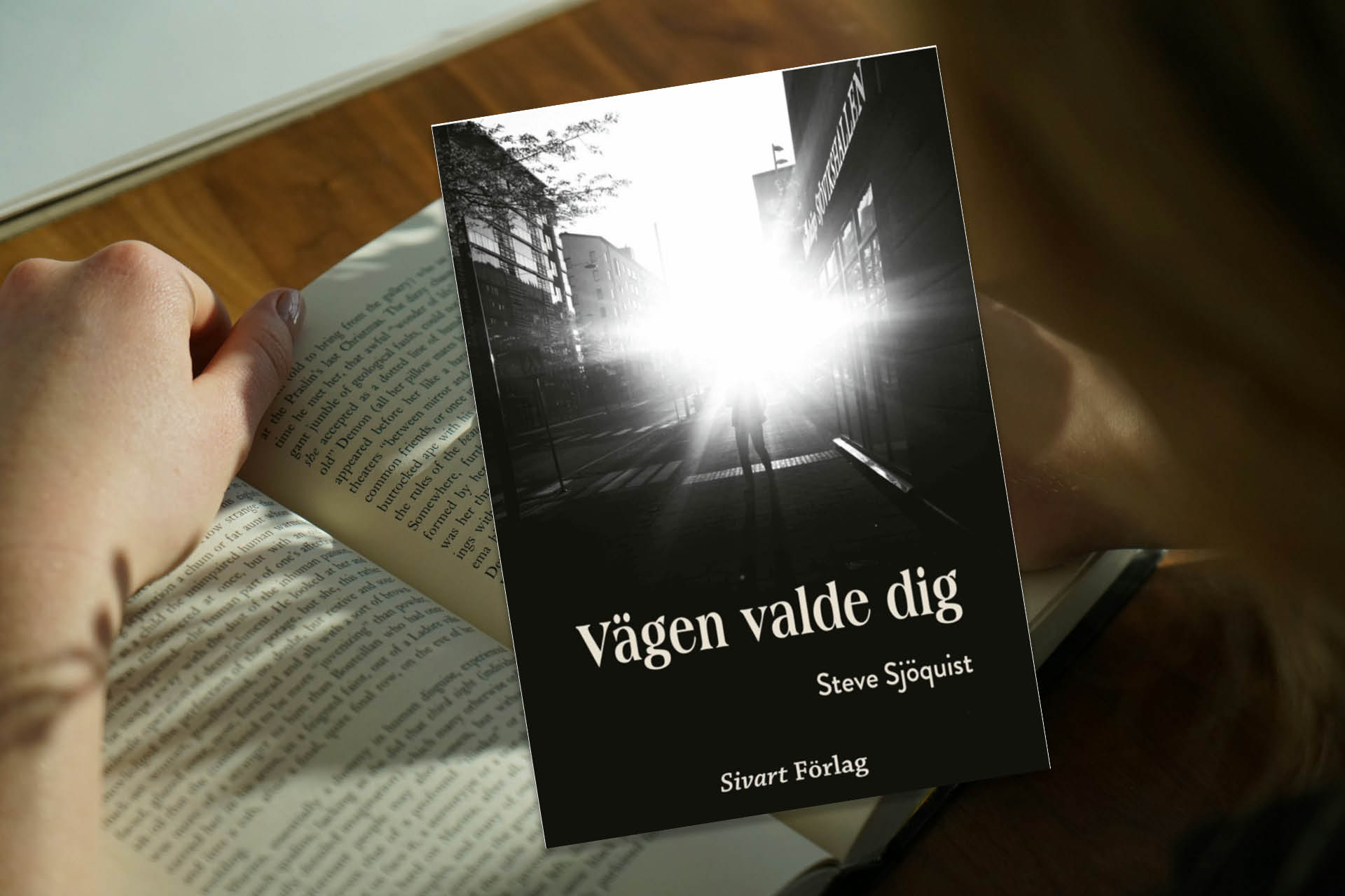 En bokframsida och i bakgrunden anas en uppslagen bok.