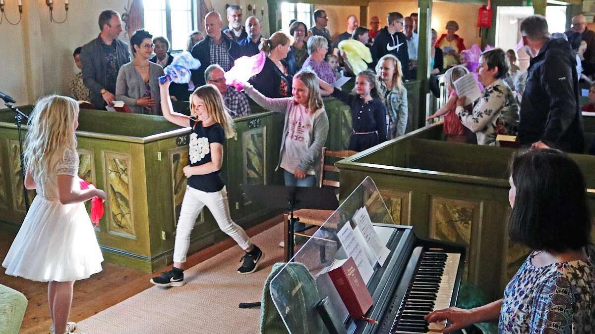 Barn som springer genom en kyrka under gudstjänst.