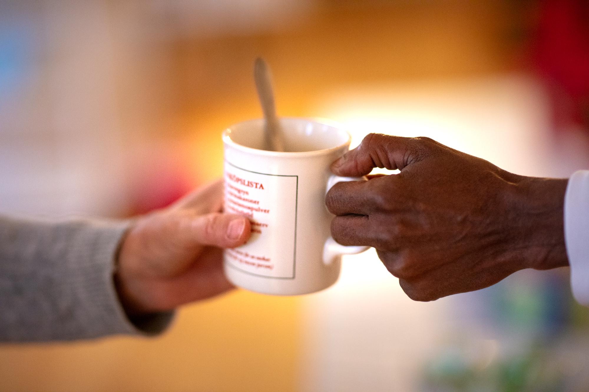 Två händer håller i samma kaffekopp. 