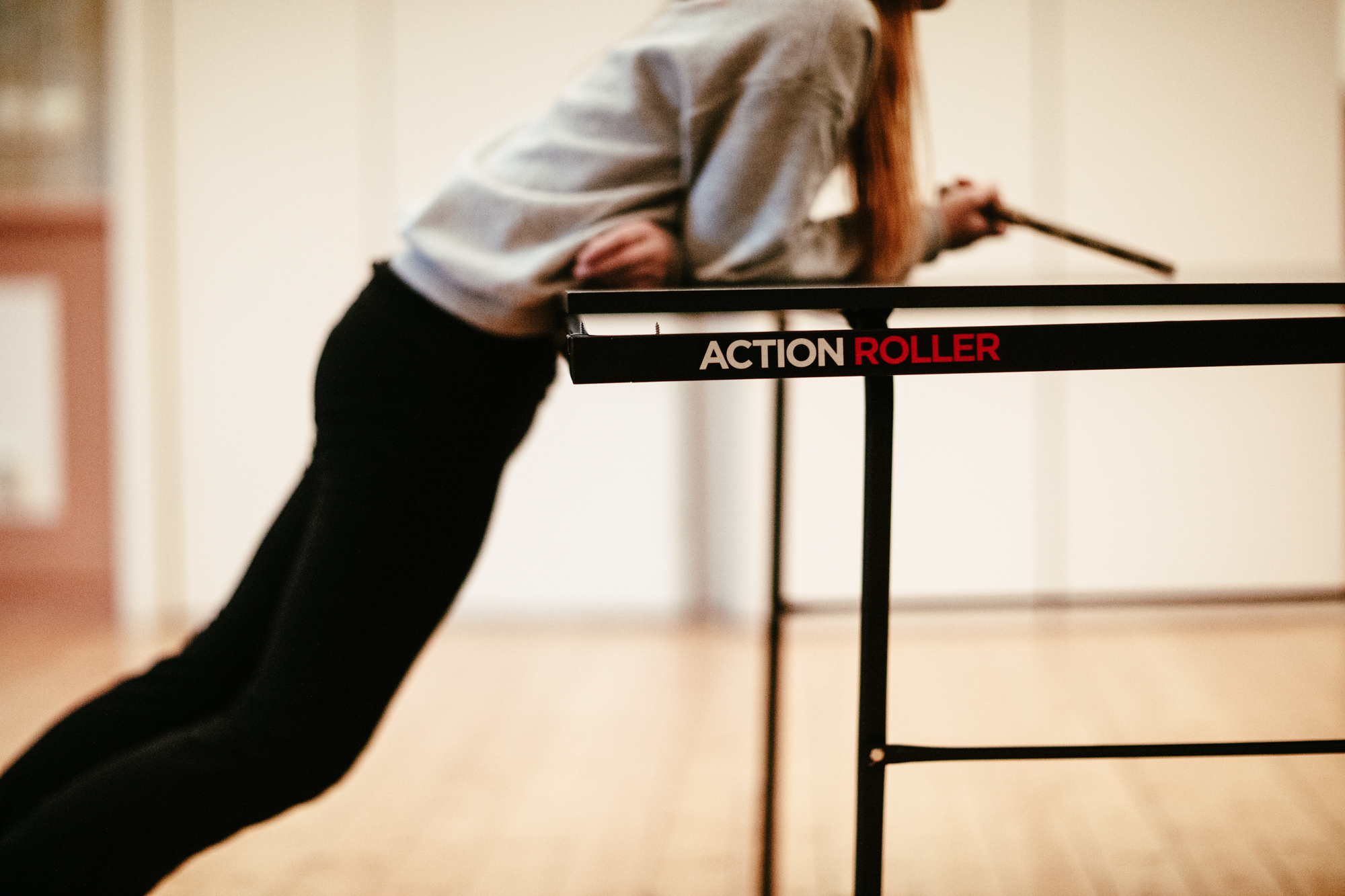 En ung person lutar sig över ett pingisbord. 