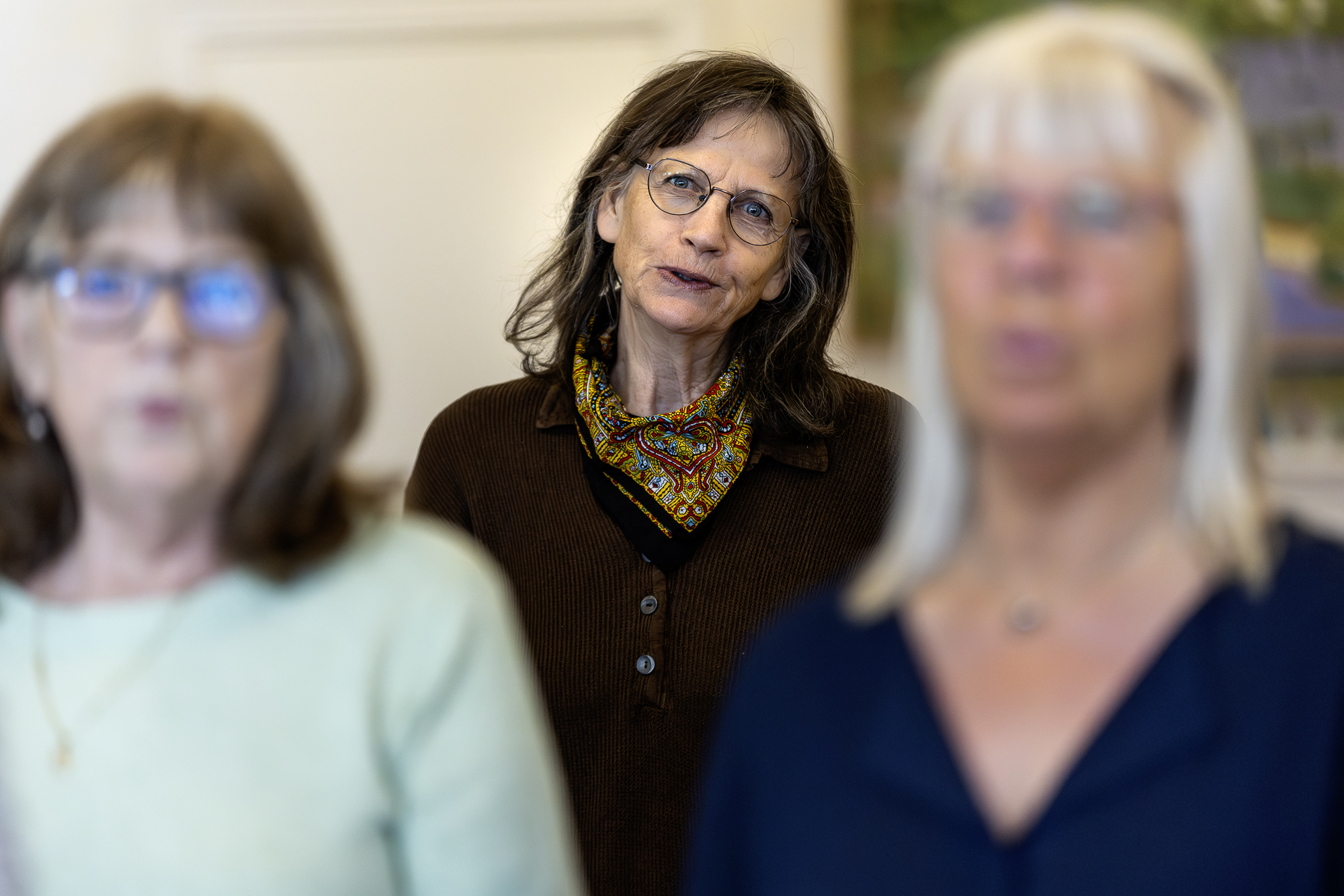 En kvinna står i en kör och sjunger