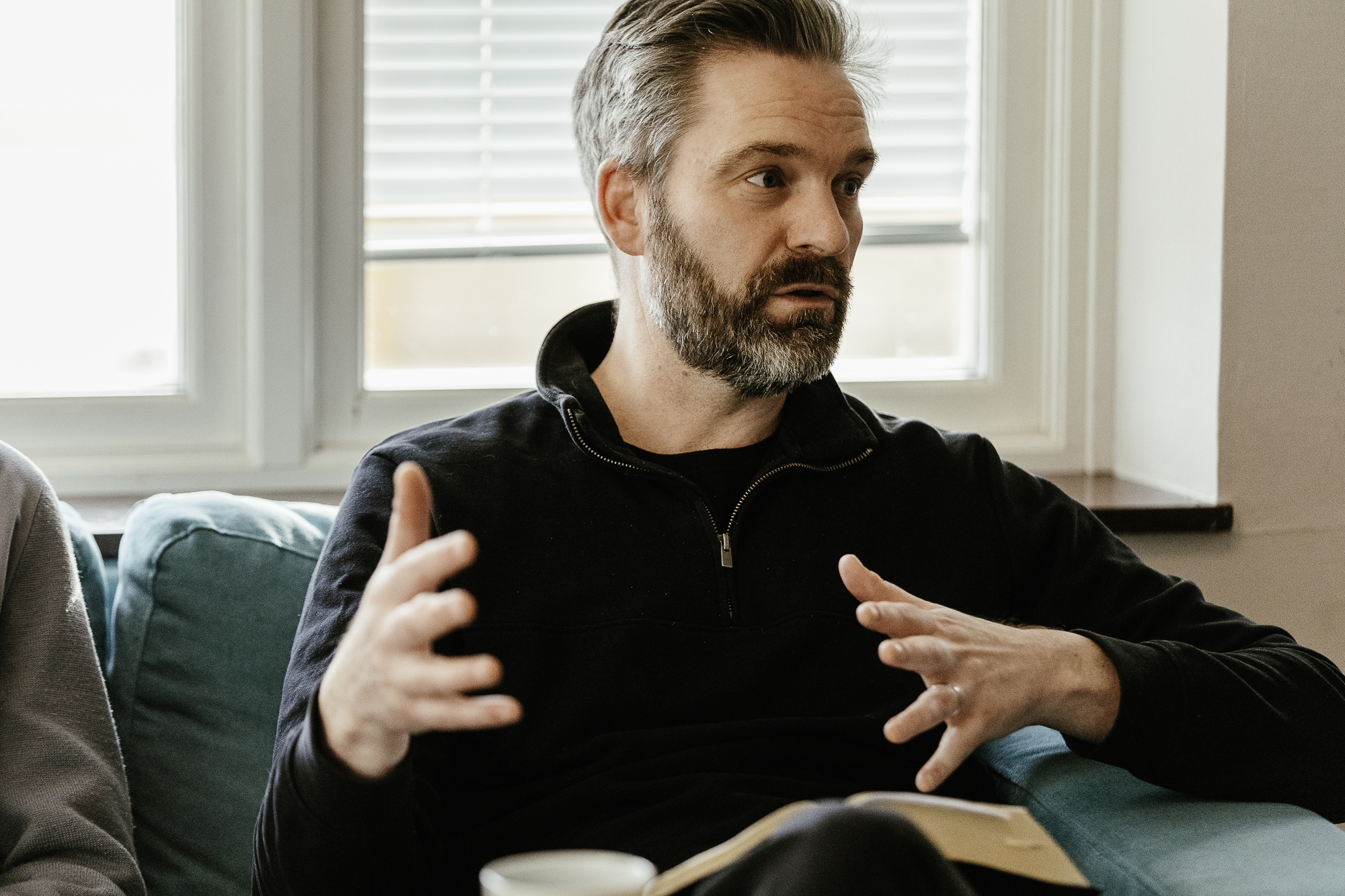 En man sitter med en bibel i knät och diskuterar dess innehåll