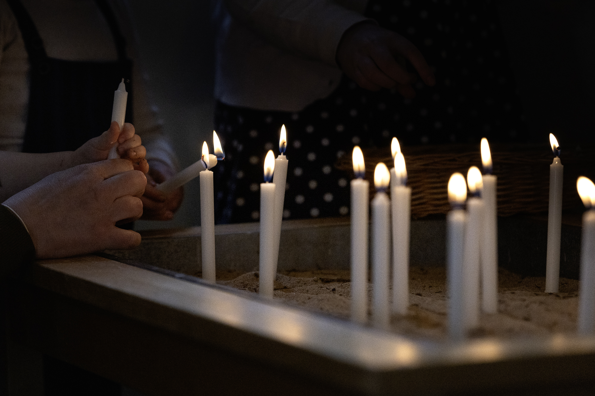 Många ljus i ett sandkar. 