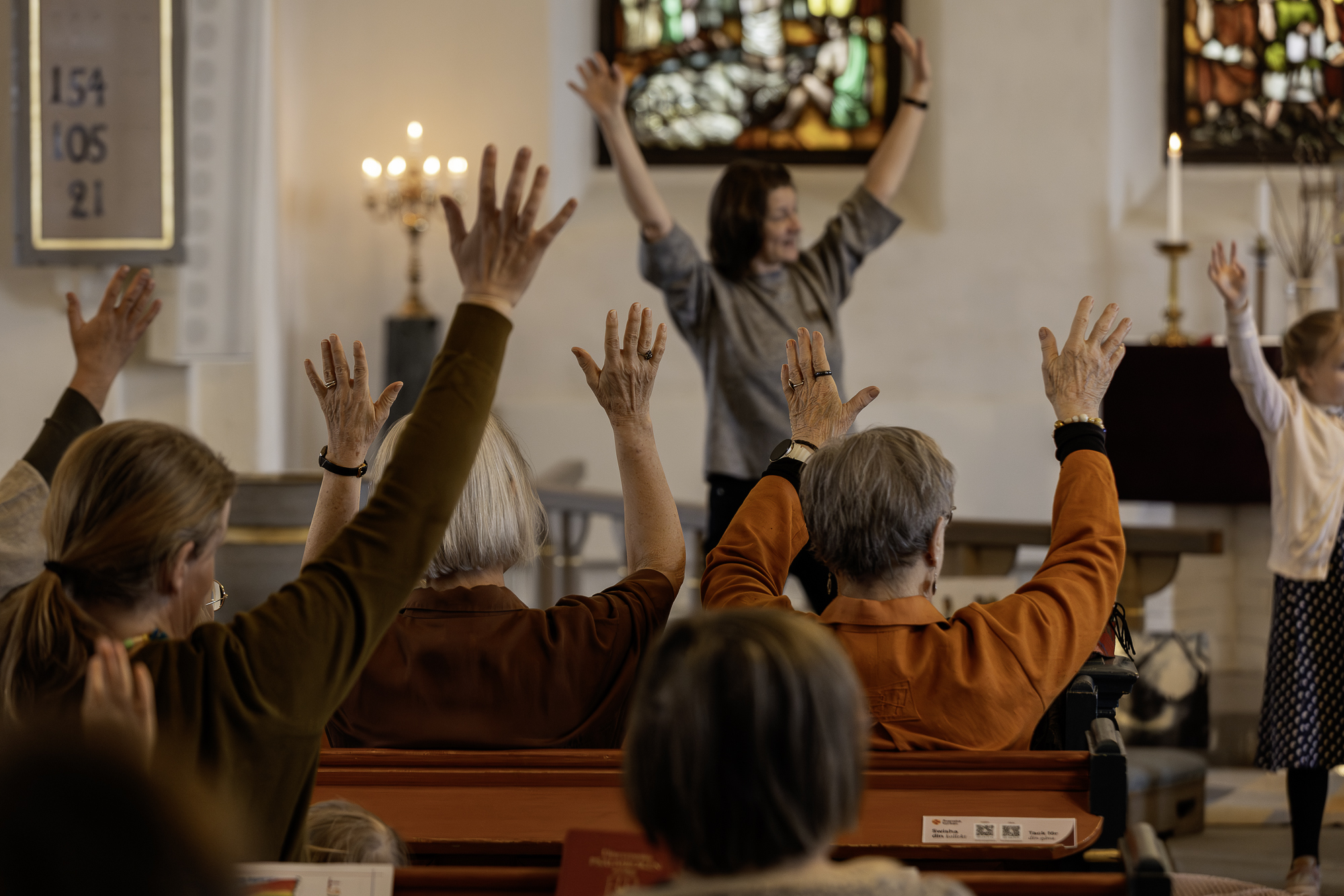 Många händer i luften under en gudstjänst